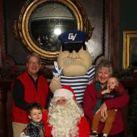 Grandparents and two grandchildren posing with Santa and Louie